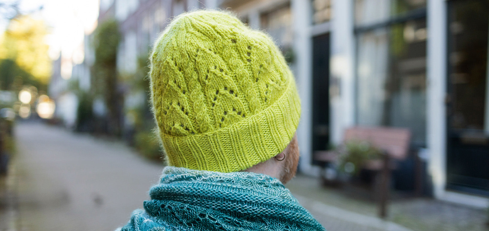 Person wearing a knitted beanie hat in pickle juice green mohair and DK merino wool 