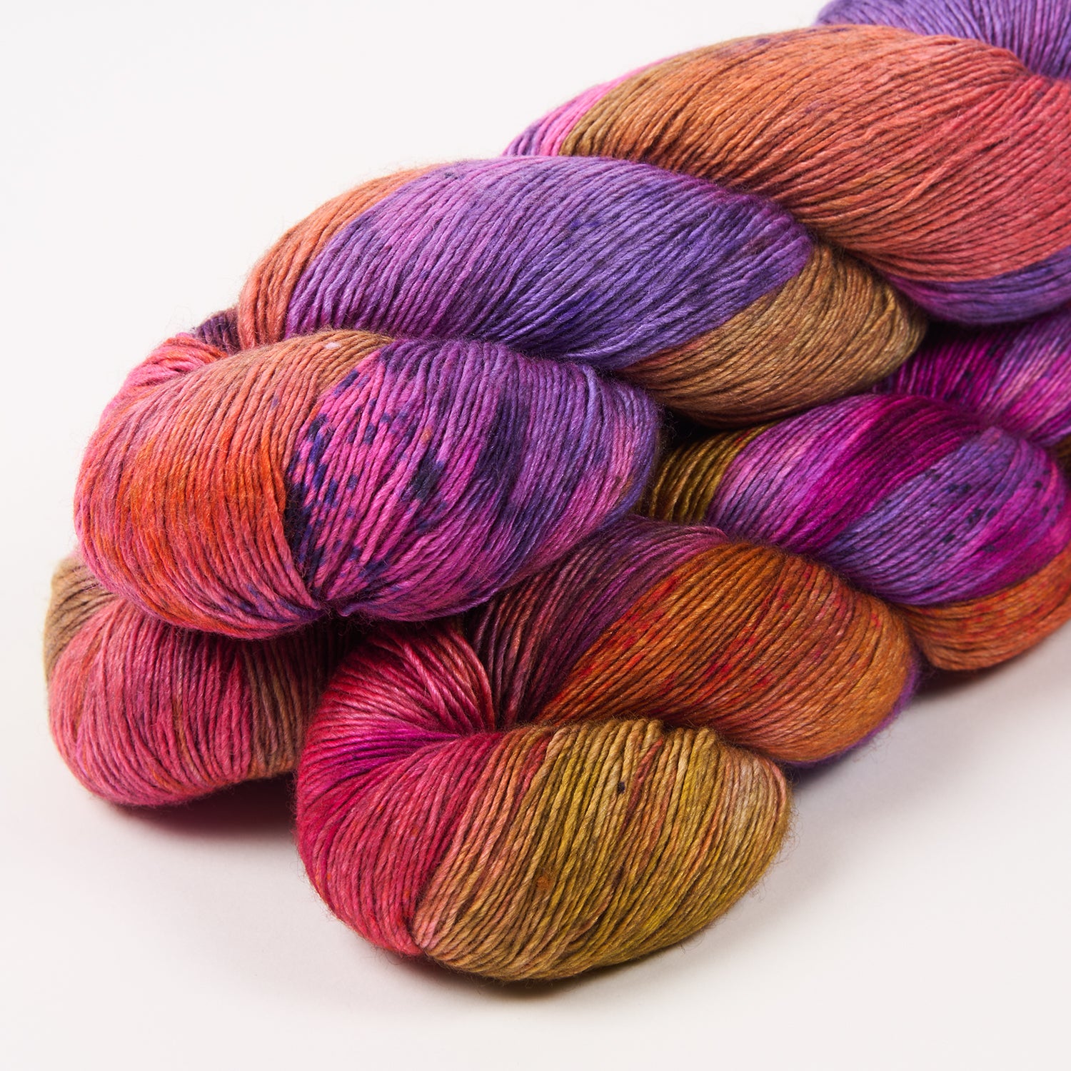 Image of 3 skeins of handdyed yarn in a blend of purple, pink and orange. The lavish Yak Silk base from Qing Fibre is a dreamy blend of superwash merino, silk, and yak perfect for delightfully soft garments and accessories.